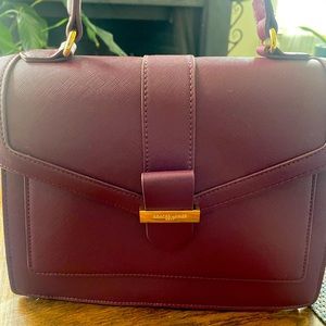 Brand new plum faux leather purse with polka dot lining. Never been used .